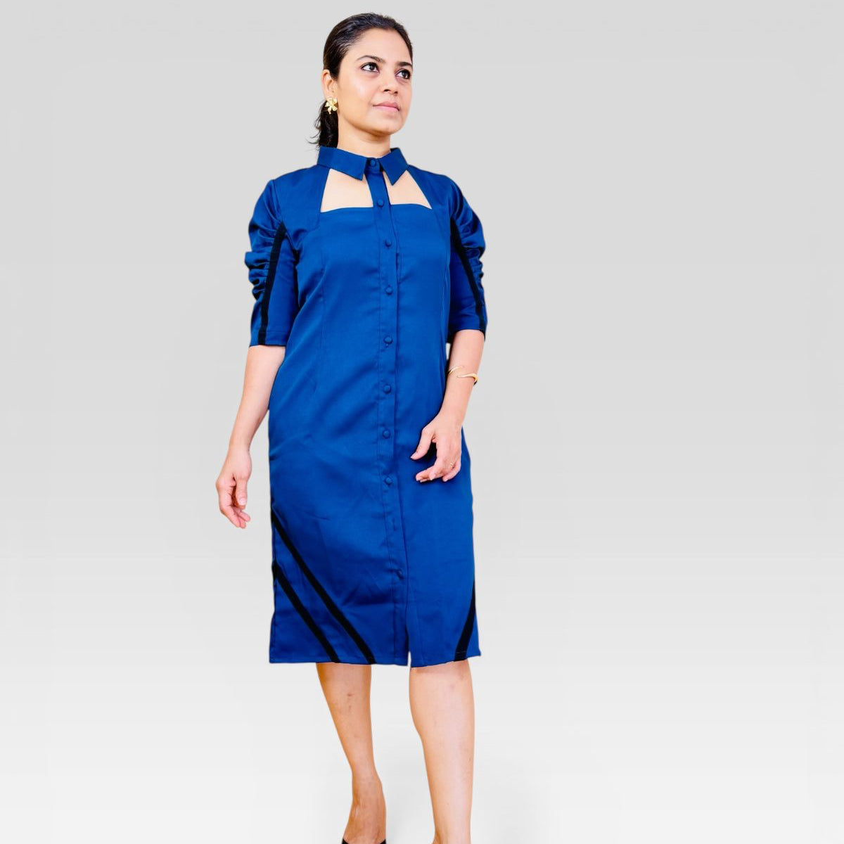 Woman wearing a blue dress with cut-out design on a white background